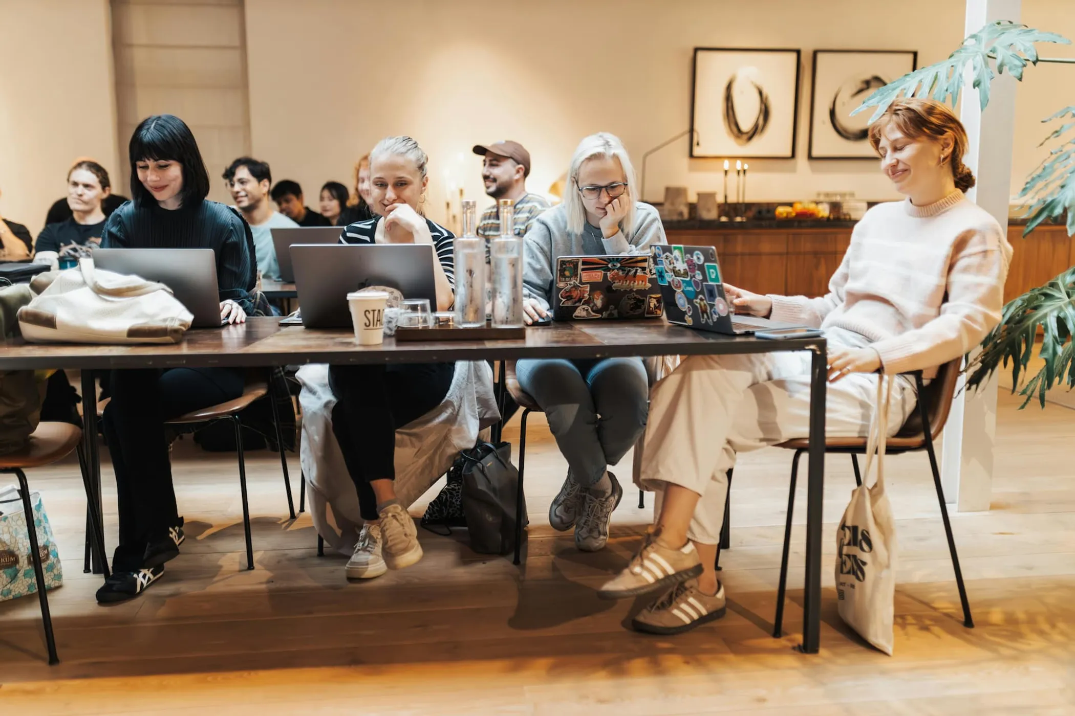 Colleagues sitting at their laptops in a common space in their office.