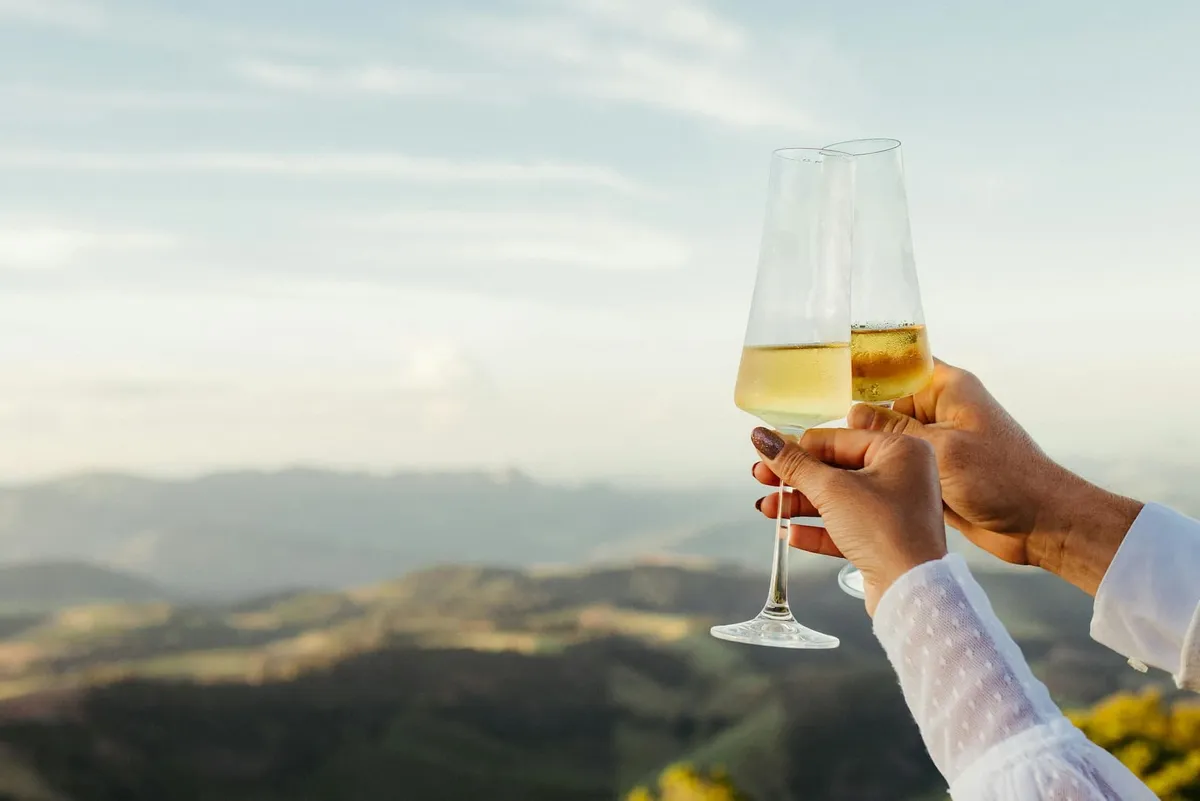 A close-up of sparkling wine glasses as a couple makes a toast.