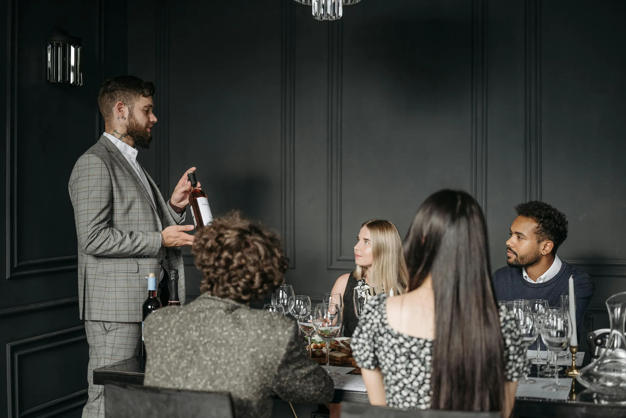 Sommelier presenting a bottle of wine during a wine tasting.